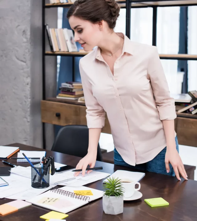 attractive young businesswoman standing at table a 2023 02 03 04 03 18 utc